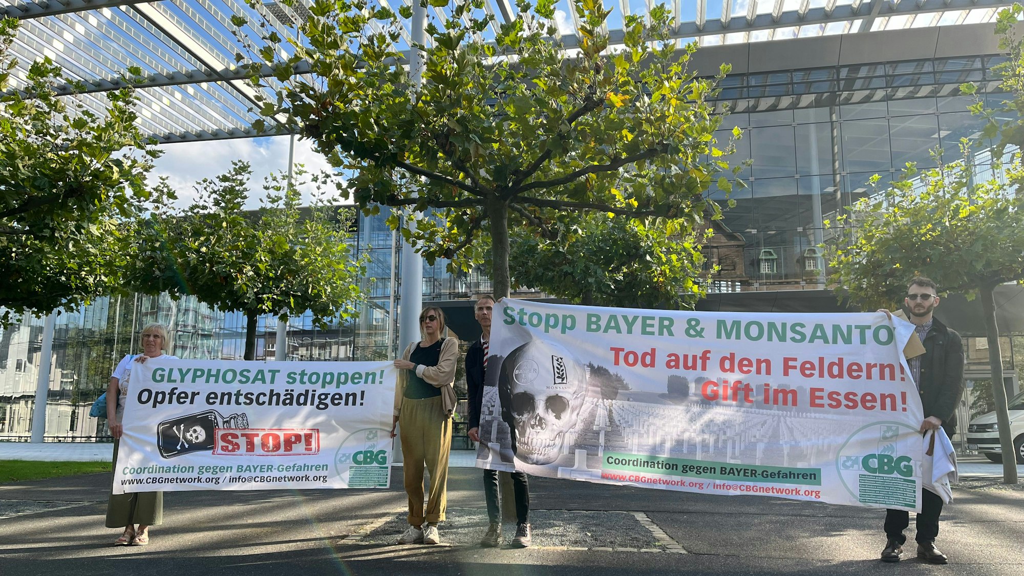 Aktivisten der „Coordination gegen Bayer-Gefahren“ stehen mit Transparenten vor der Konzernzentrale