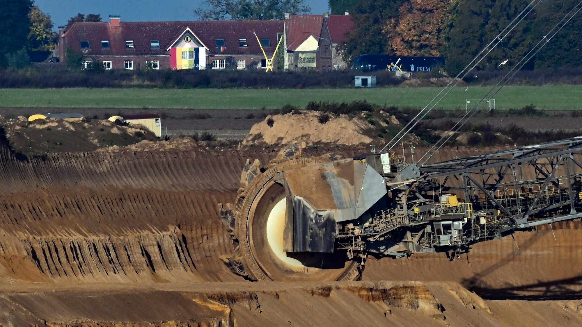Ein Schaufelradbagger arbeitet im Braunkohletagebau Garzweiler. Im Hintergrund ist die Ortschaft Lützerath zu sehen. Der Kohleausstieg im Rheinischen Revier in Nordrhein-Westfalen soll um acht Jahre auf das Jahr 2030 vorgezogen werden. Angesichts der aktuellen Energiekrise sollen zugleich zwei Braunkohlekraftwerke länger als bisher geplant laufen. Foto: Federico Gambarini/dpa +++ dpa-Bildfunk +++