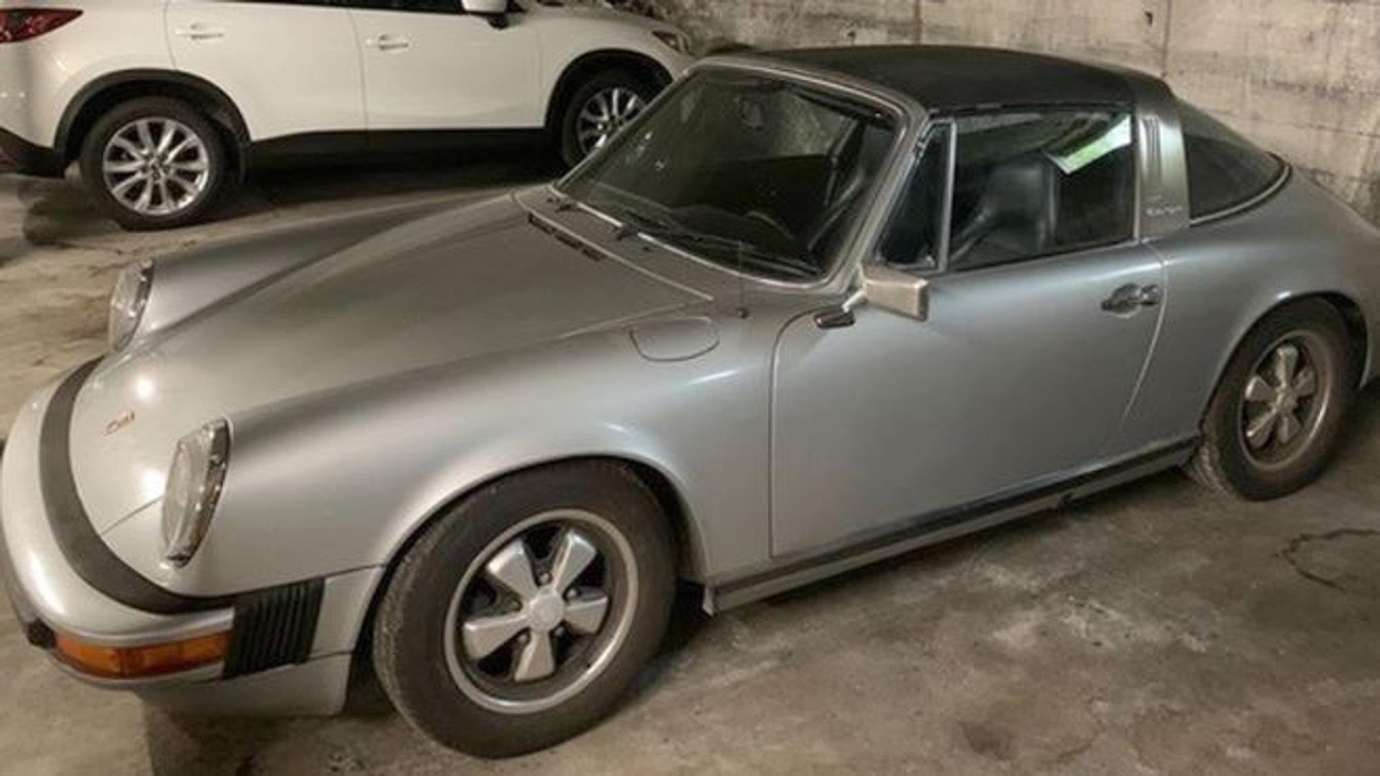 Ein grauer Porsche steht in einer Tiefgarage.