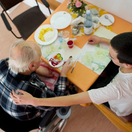 Im AWO-Seniorenheim betreut ein Pfleger einen Mann.