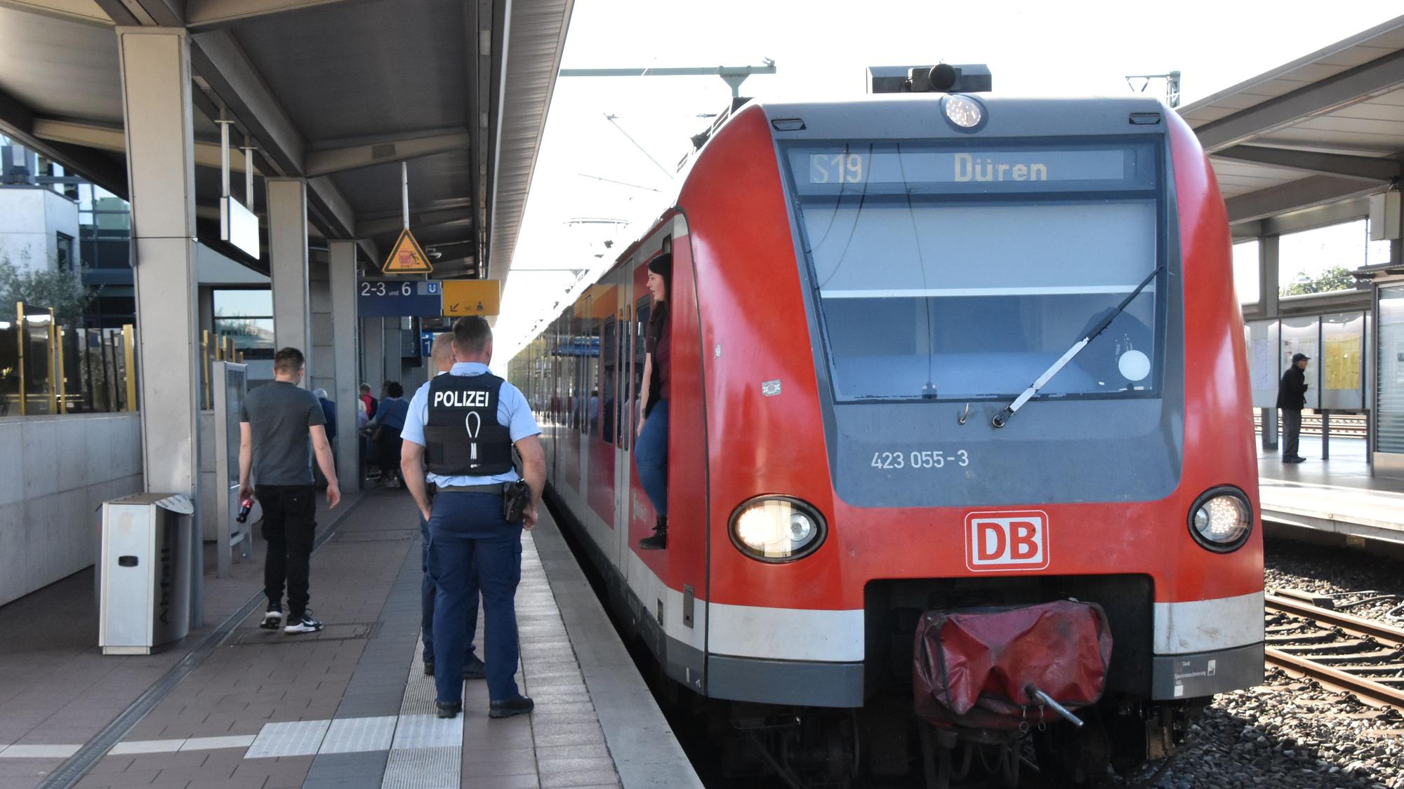 Polizisten stehen an der S-Bahn der Linie 19 am Siegburger Bahnhof.