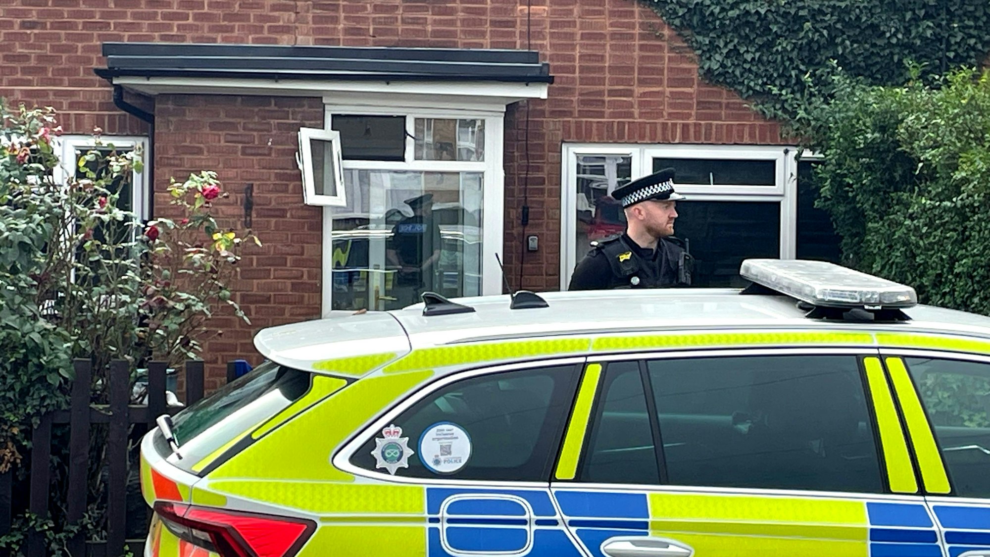 Ein Polizeibeamter steht vor einem Haus in der Main Street, nachdem ein Mann von zwei Hunden gebissen und schwer verletzt wurde.