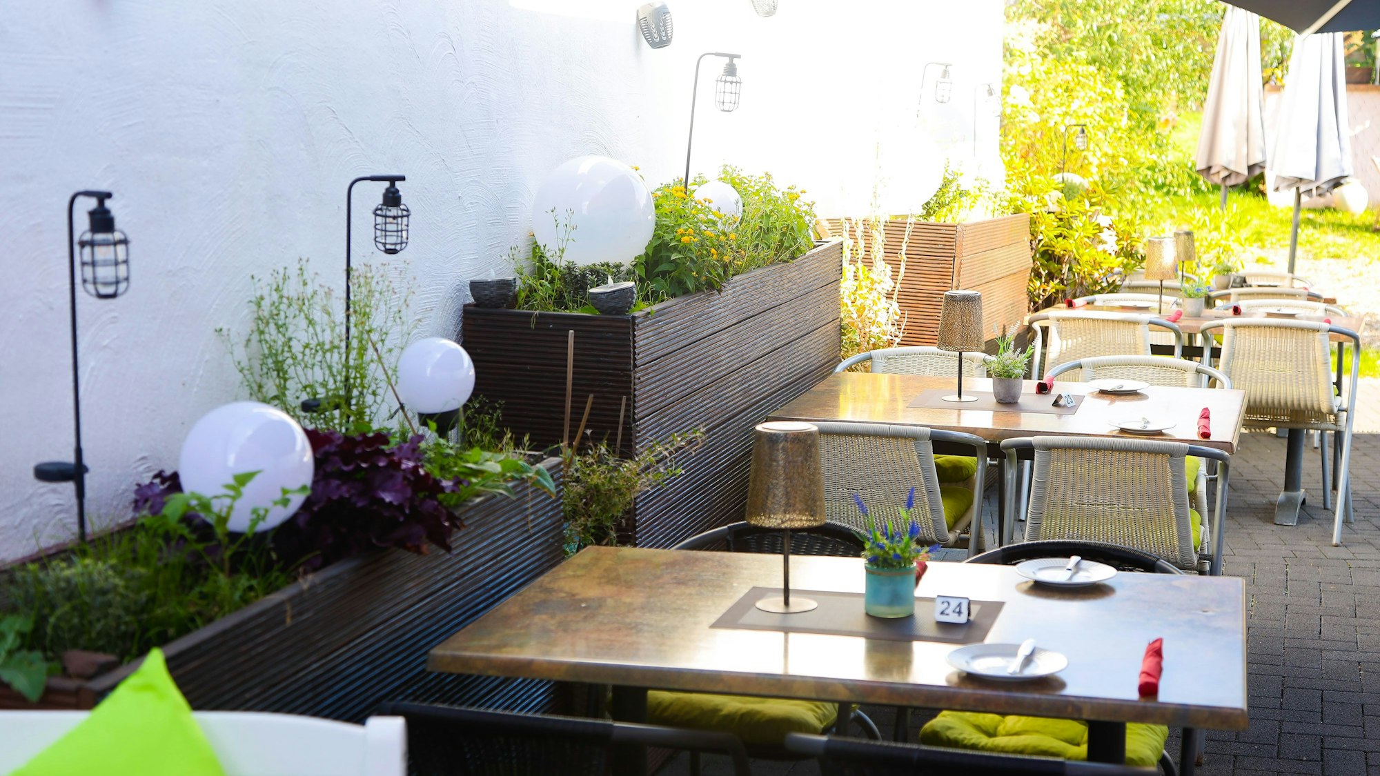 Hochbeete, Tische und Stühle im Hinterhof des Ristaurante Da Mario.