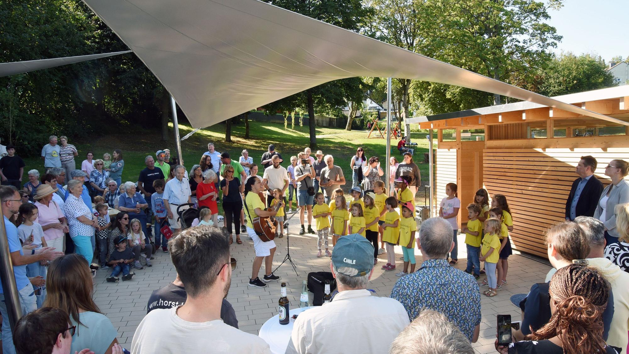 Ein Kinderchor wird von Festbesuchern umringt.
