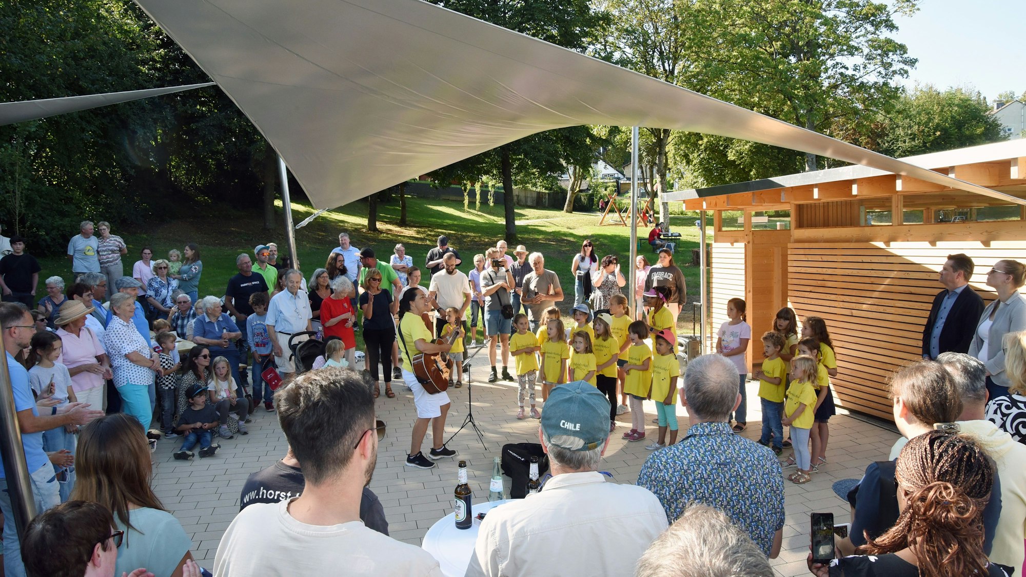 Ein Kinderchor wird von Festbesuchern umringt.