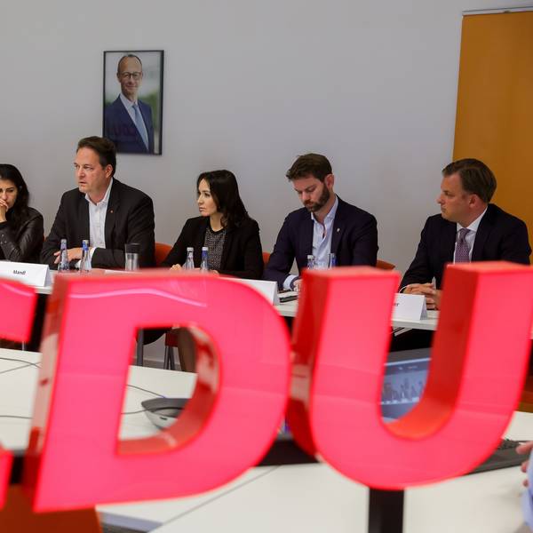 Der Vorstand der Kölner CDU sitzt hinter dem Parteilogo an einem Tisch.