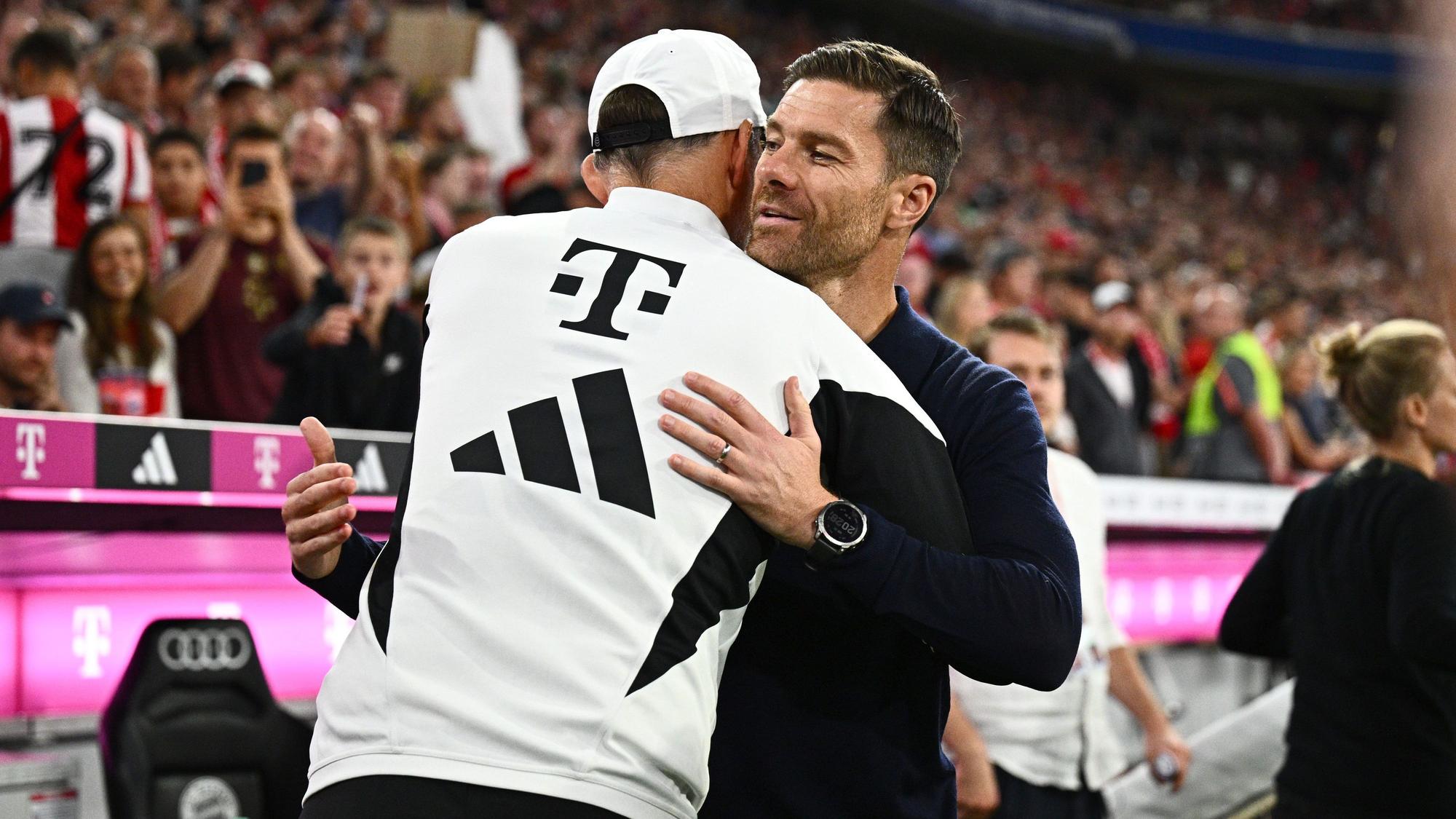 Münchens Trainer Thomas Tuchel (l) und Leverkusens Trainer Xabier Alonso umamren sich in der Allianz Arena.