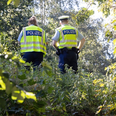 Polizisten sichern einen möglichen Tatort an einem Bahndamm im Hamburger Stadtteil Lokstedt.