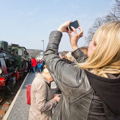 Am Wiehler Bahnhof fotografiert eine Frau eine Dampflok.