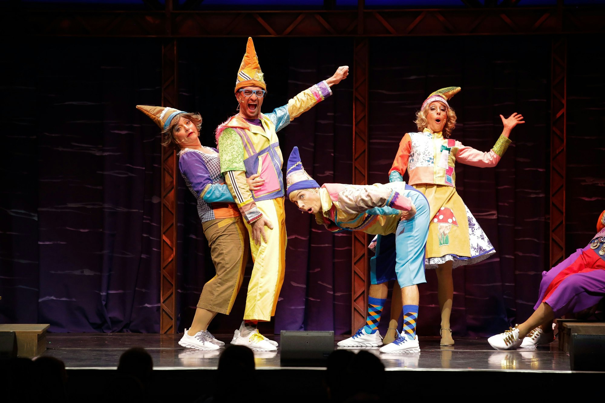 Vier als Heinzelmännchen verkleidete Menschen, einem wird der Popo versohlt.