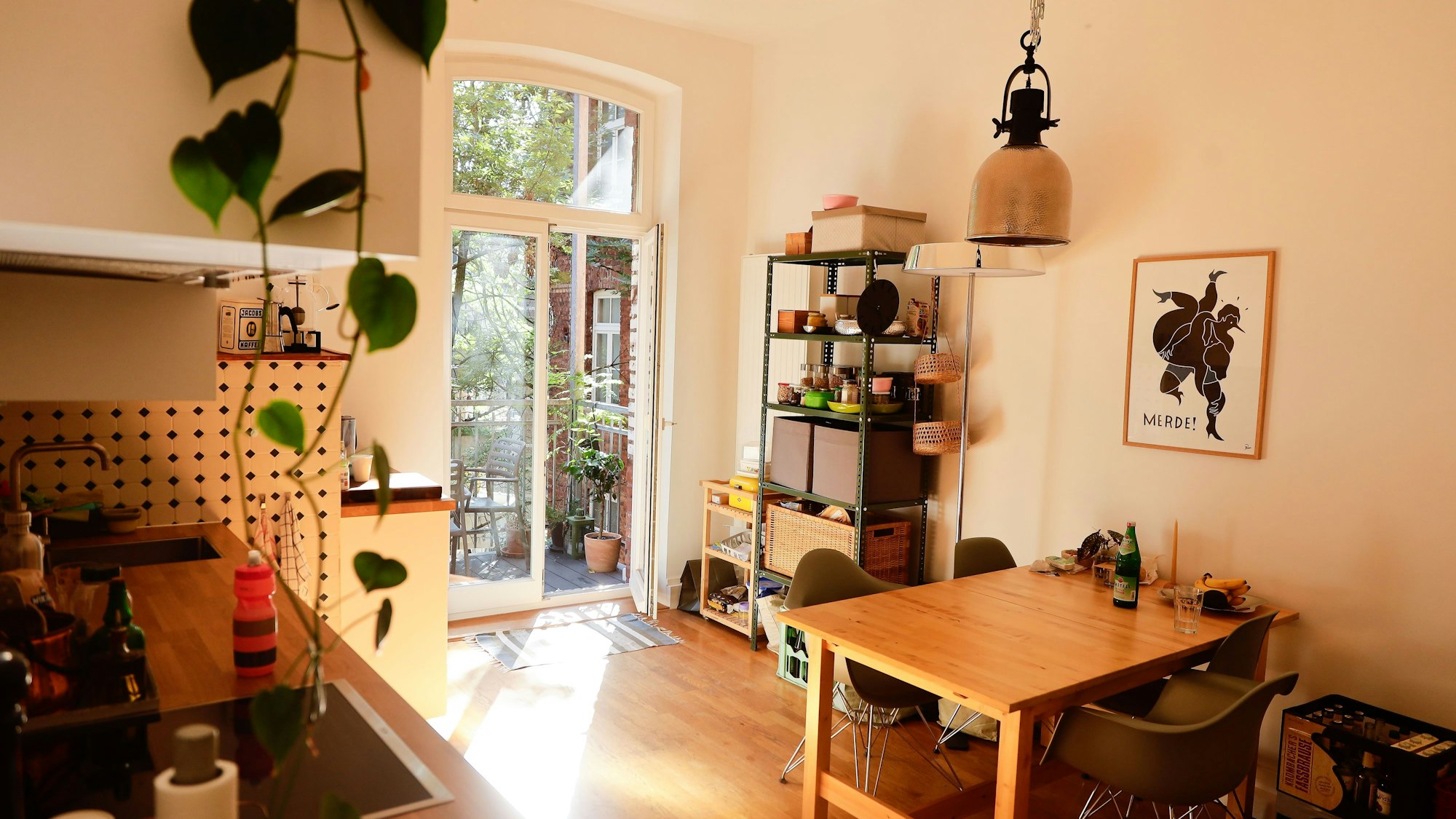 Das Foto zeigt eine Essküche mit einem Tisch und einer Tür zum Balkon.