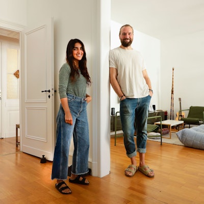 Daniel Nienkämper und Mana Kakuan stehen in ihrem Wohnzimmer.