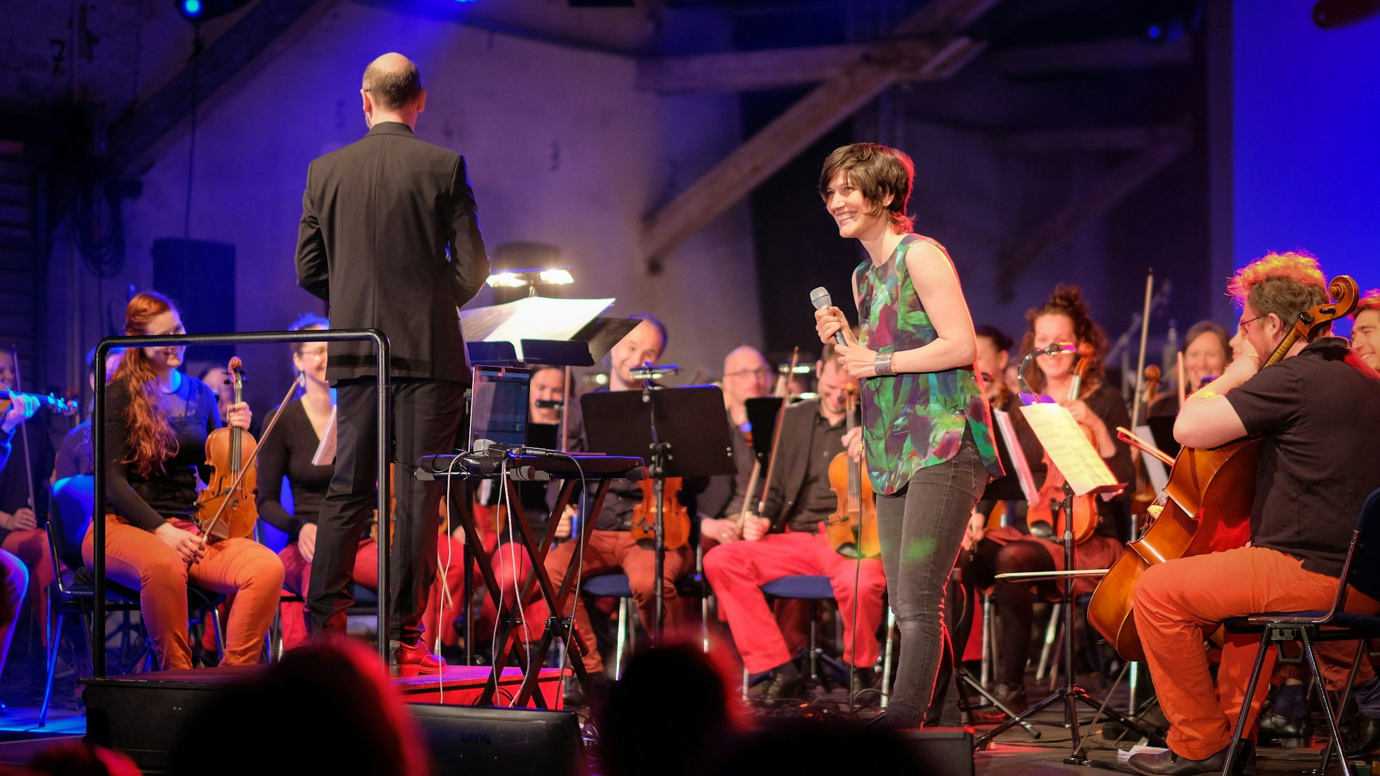 Alin Coen mit den Musikern des Orchesters auf einer Bühne