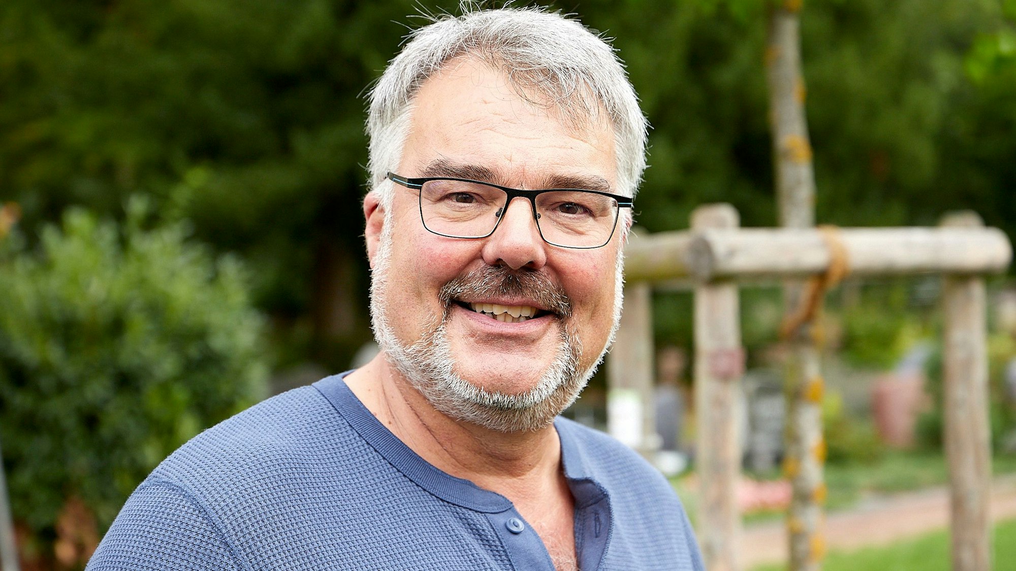 Pfarrer Erik Schumacher lächelt in die Kamera. Er trägt Brille und einen gepflegten Bart.