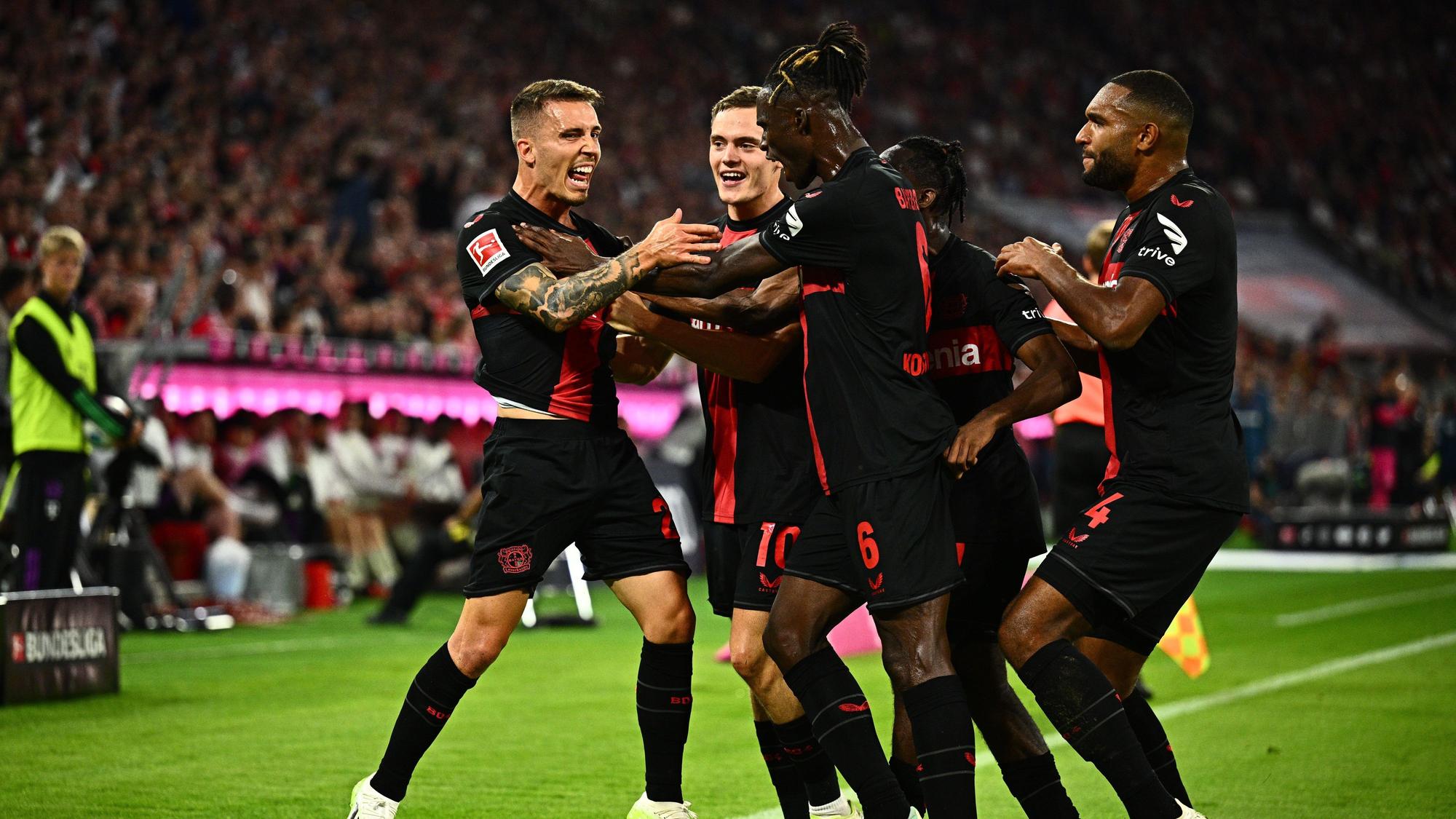 Leverkusens Alejandro Grimaldo (l) feiert mit Teamkollegen sein Tor zum 1:1.