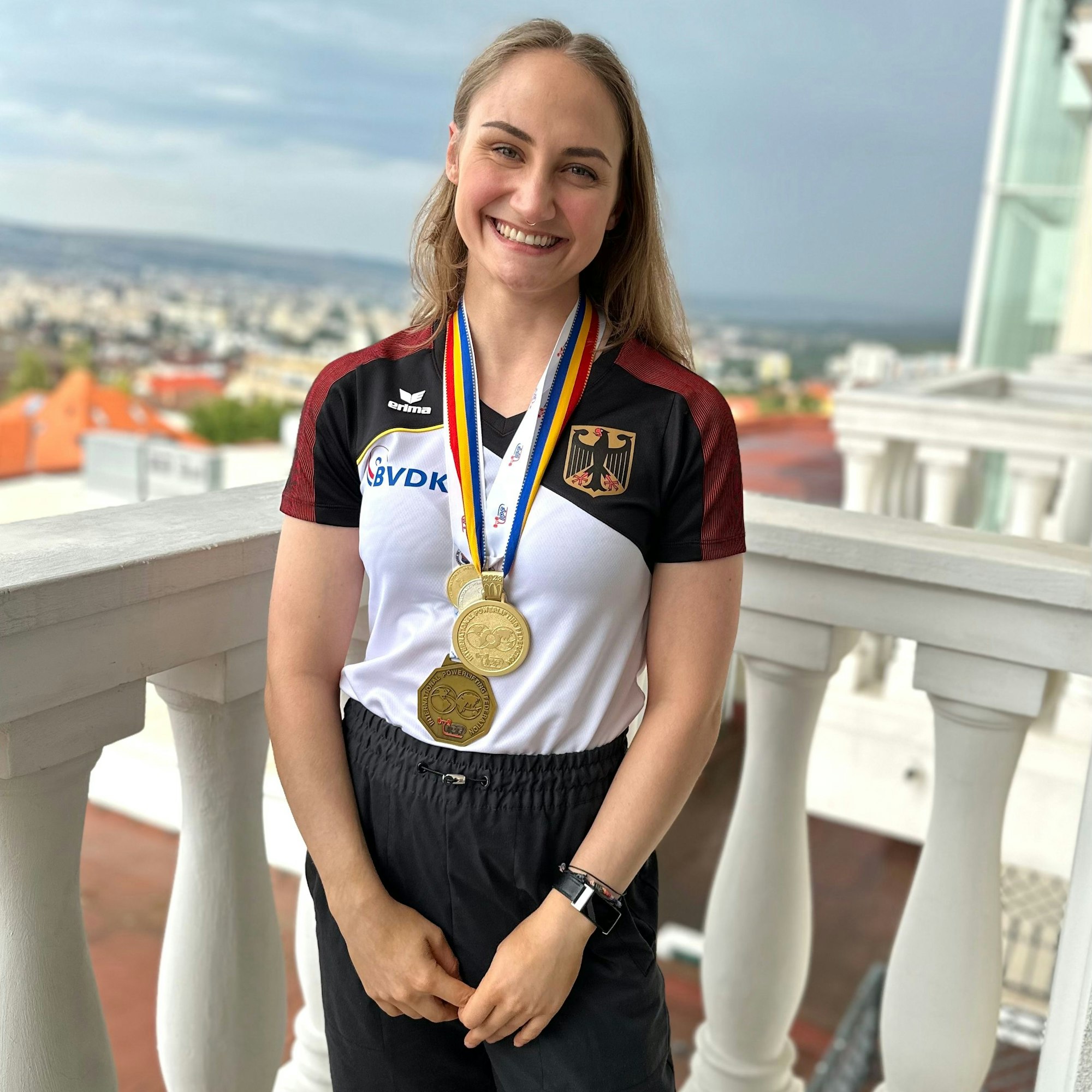 Lächelnd trägt Helena Decker auf ihrem Nationaltrikot die Goldmedaille.
