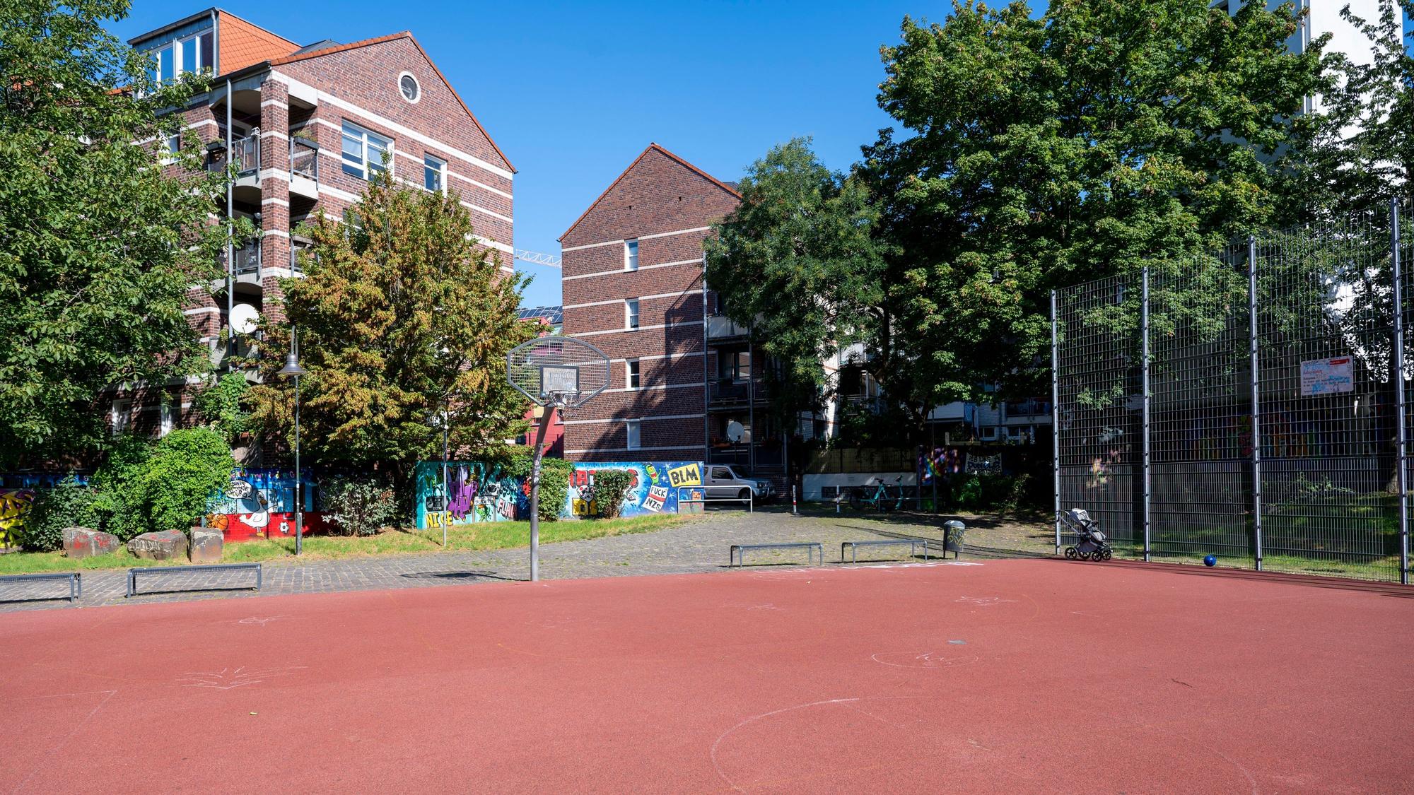 Blick auf den Basketballplatz an der Elsaßstraße mit rotem Tartanboden.