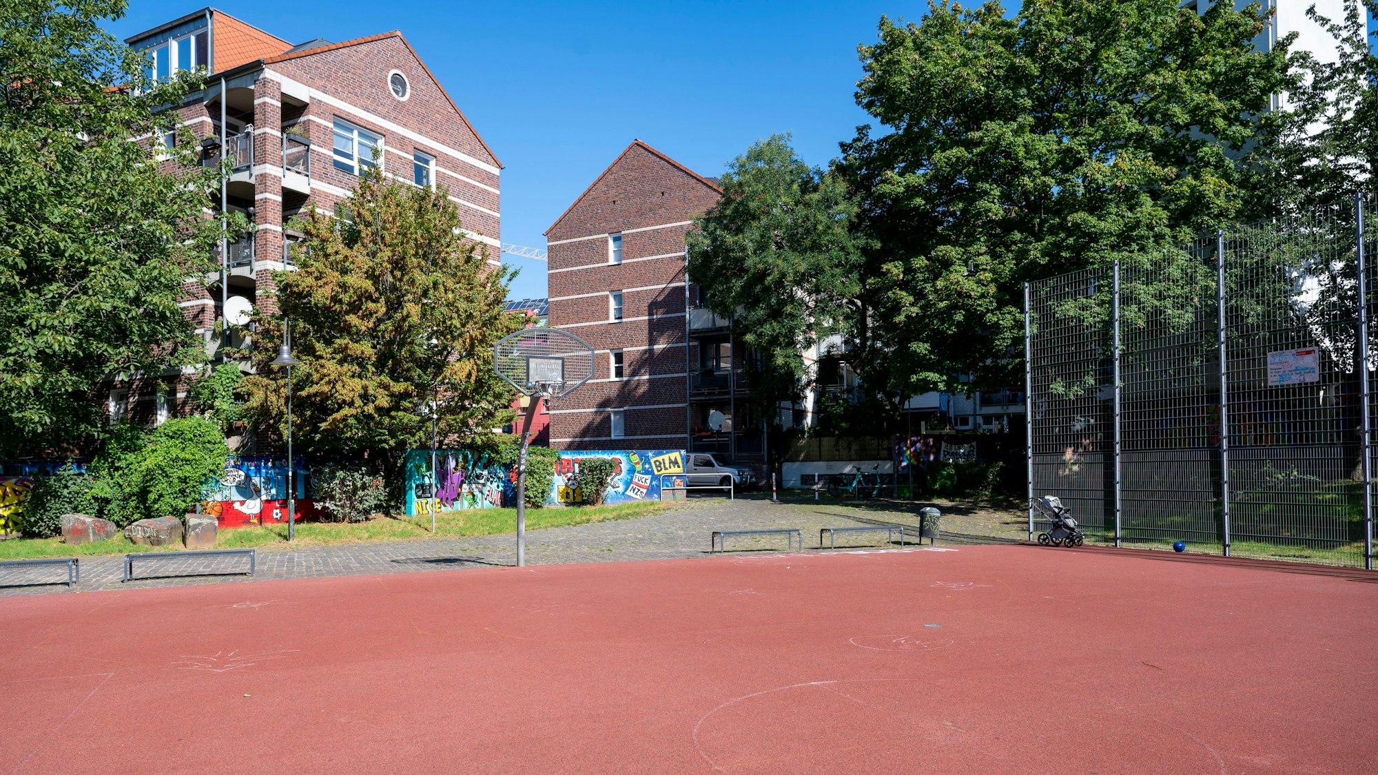 Blick auf den Basketballplatz an der Elsaßstraße mit rotem Tartanboden.