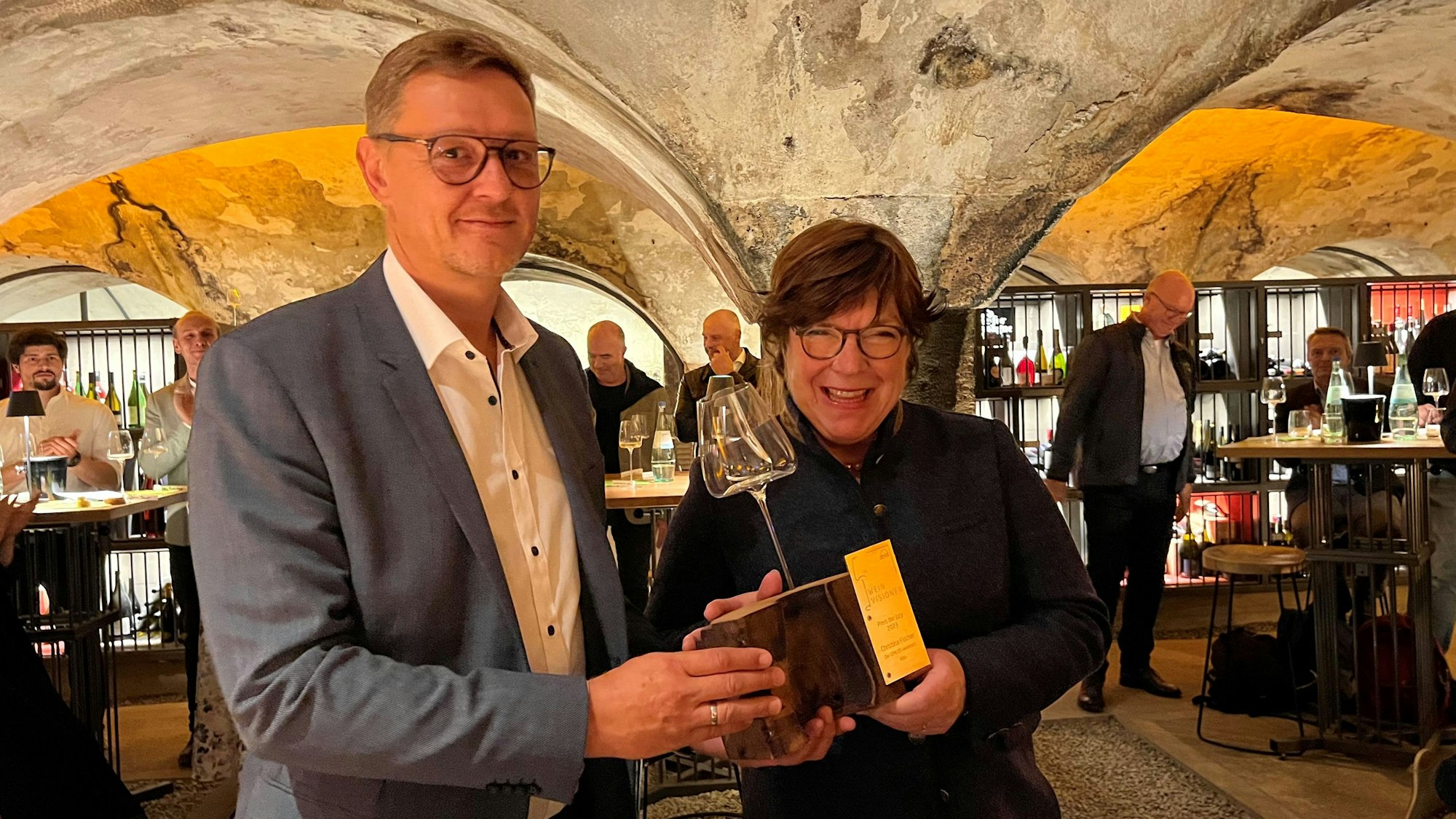 Christina Fischer nimmt den Preis von Dominik Zieher entgegen.