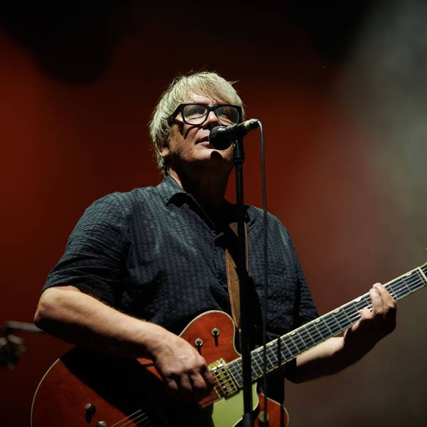 Element of Crime live 2023: Sänger Sven Regener steht am Mikrofon und spielt E-Gitarre.