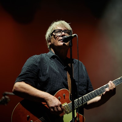 Element of Crime live 2023: Sänger Sven Regener steht am Mikrofon und spielt E-Gitarre.