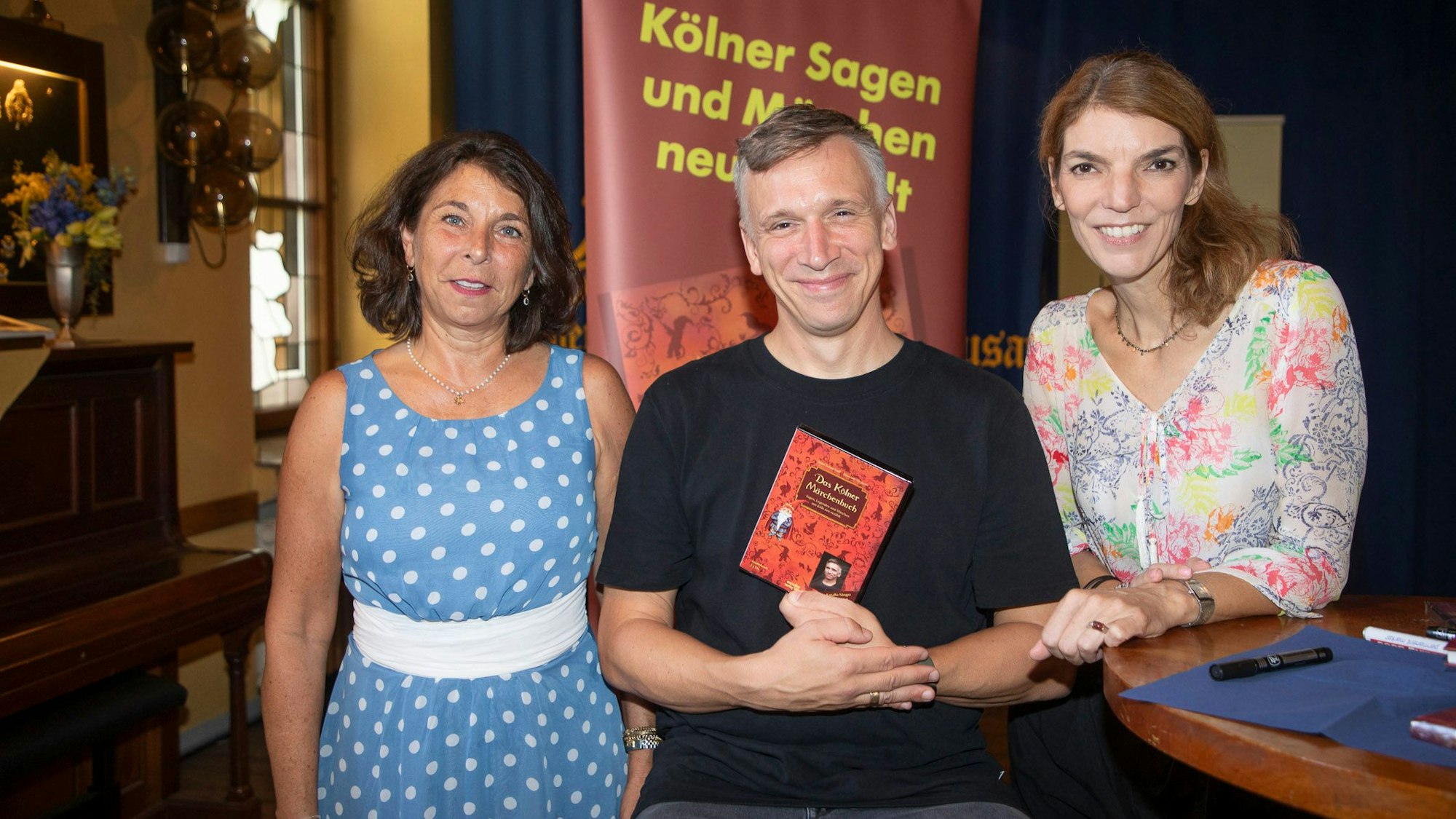 Bastian Campmann hält das Hörbuch in der Hand, die zwei Autorinnen stehen neben ihm.