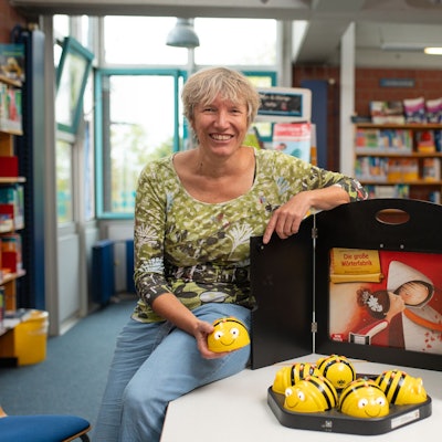 Das Bild zeigt die Büchereileiterin mit Mini-Mobotern in Form von Bienen.