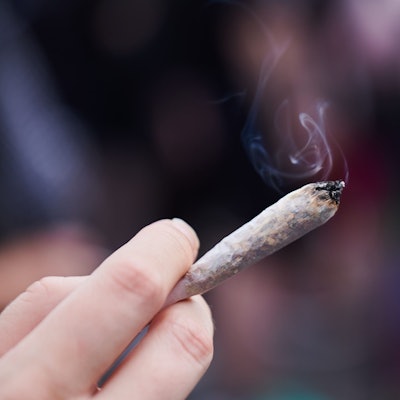 Eine Frau hält einen Joint mit Cannabis in der Hand. In Hamburg werden Stimmen lauter, die die Cannabis-Legalisierung nicht hinnehmen wollen. (Symbolbild)