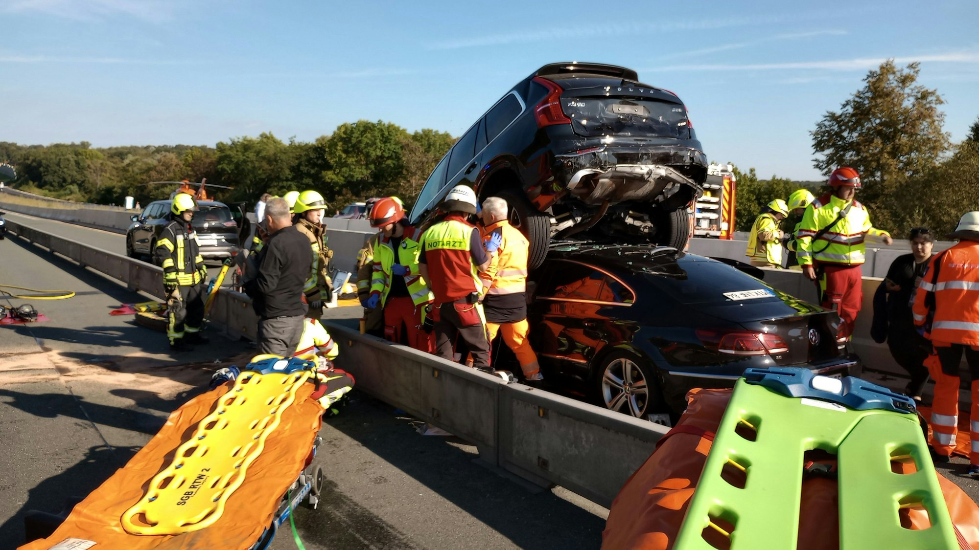 Rettungskräfte bergen einen Menschen aus einem zerstörten Auto.
