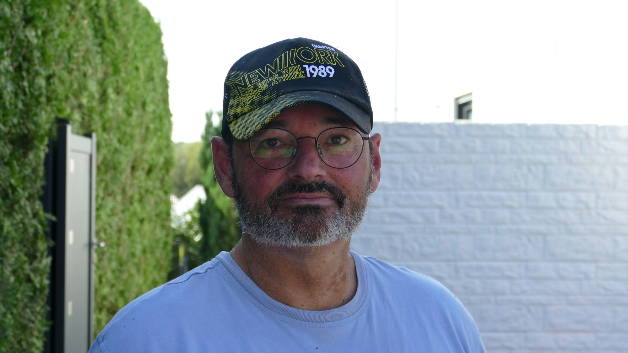 Peter Rößler steht vor der Hecke, die er schnitt, als es bei den Nachbarn brannte.