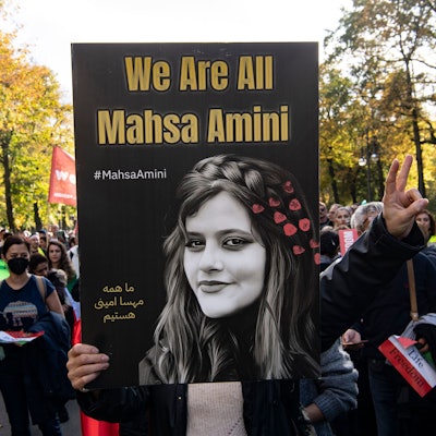 Ein Teilnehmer der Großdemonstration „Solidarität mit den Protestierenden im Iran“ hält am Großen Stern ein Plakat mit der Aufschrift ‚We Are All Mahsa Amini‘ hoch. (Archivbild aus 2022).