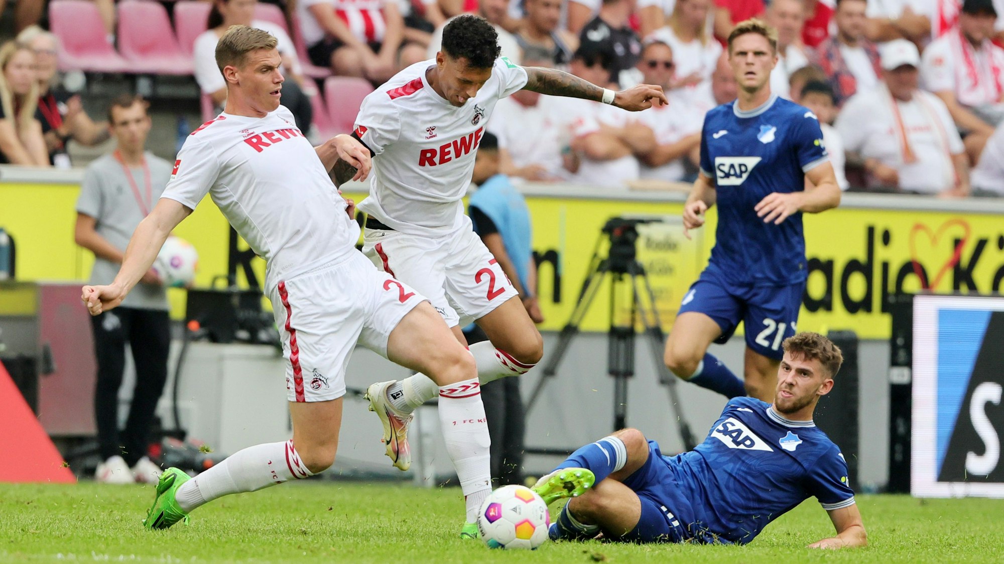 Die FC-Spieler Steffen Tigges und Davie Selke im Duell um den Ball gegen Anton Stach von TSG Hoffenheim.