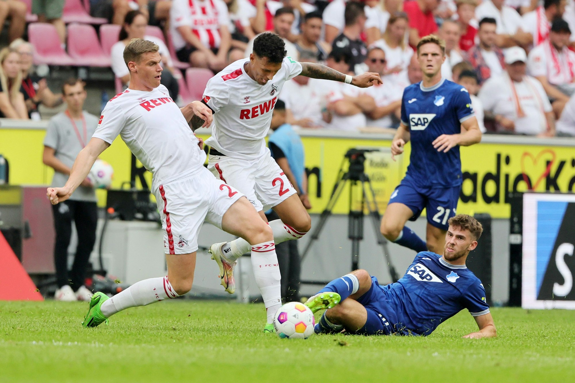Die FC-Spieler Steffen Tigges und Davie Selke im Duell um den Ball gegen Anton Stach von TSG Hoffenheim.