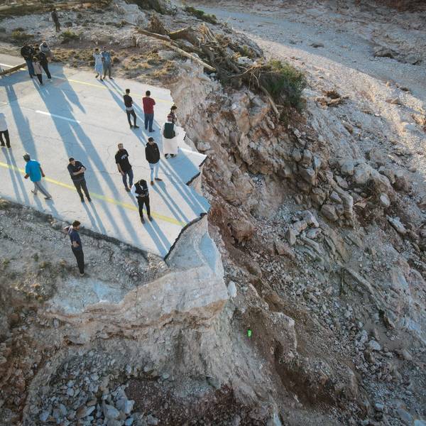 Menschen stehen an einer durch die Überschwemmungen zerstörten Straße im Osten Libyens nahe der Hafenstadt Darna, wo 20.000 Tote befürchtet werden.