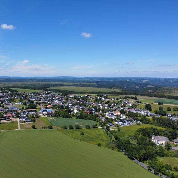 Eine Luftaufnahme zeigt das Dorf Dreiborn. Drumherum sind grüne Wiesen und Felder zu sehen.