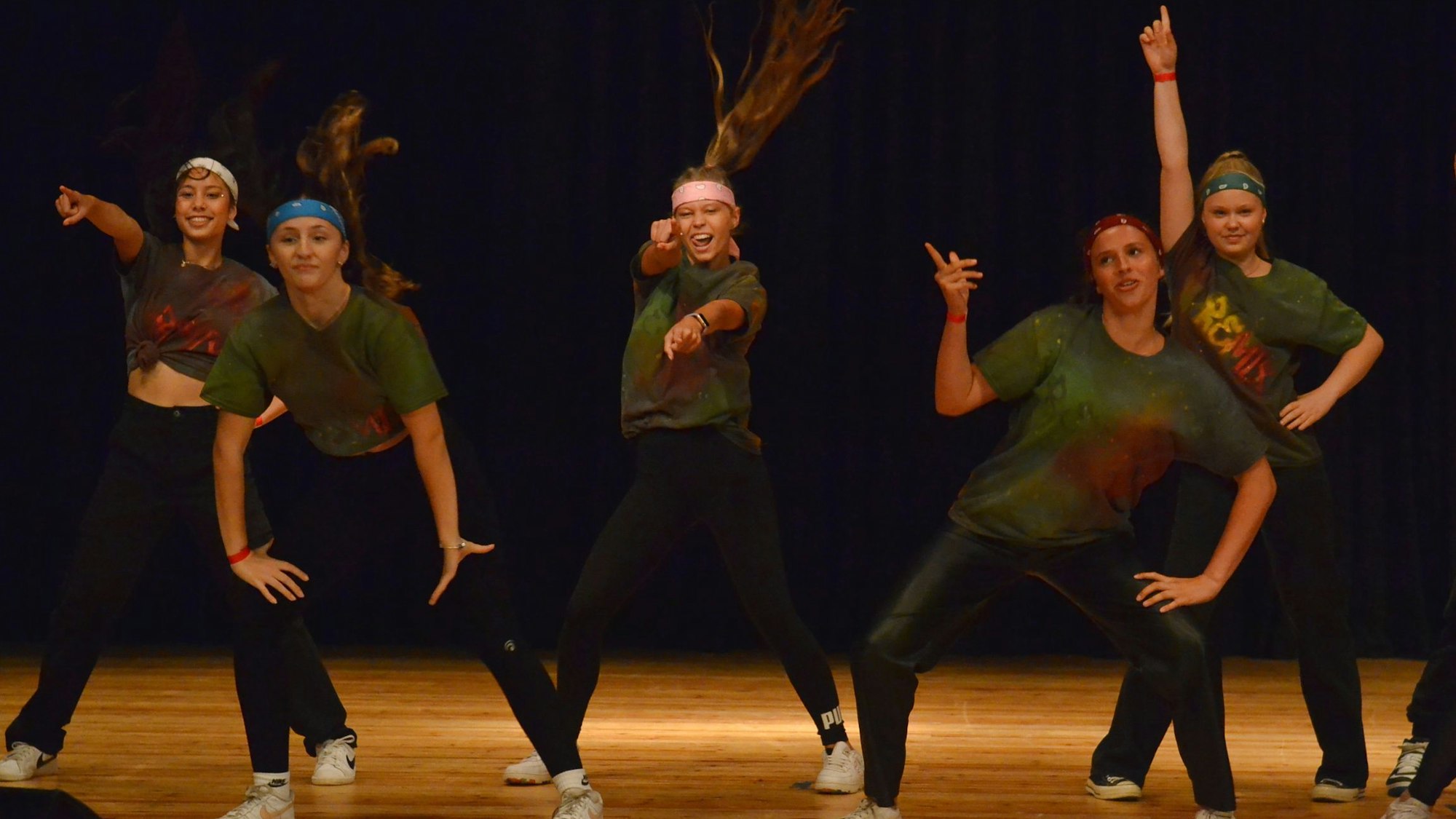 Eine Gruppe junger Frauen tanzt auf einer Bühne.