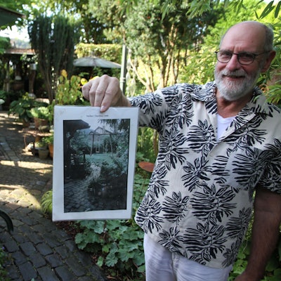 Bergische Gartentour 2023, offene Gärten, Michael Panthen in Lohmar-Neuhonrath hält ein Foto von seinem Garten vor der Umgestaltung in die Kamera