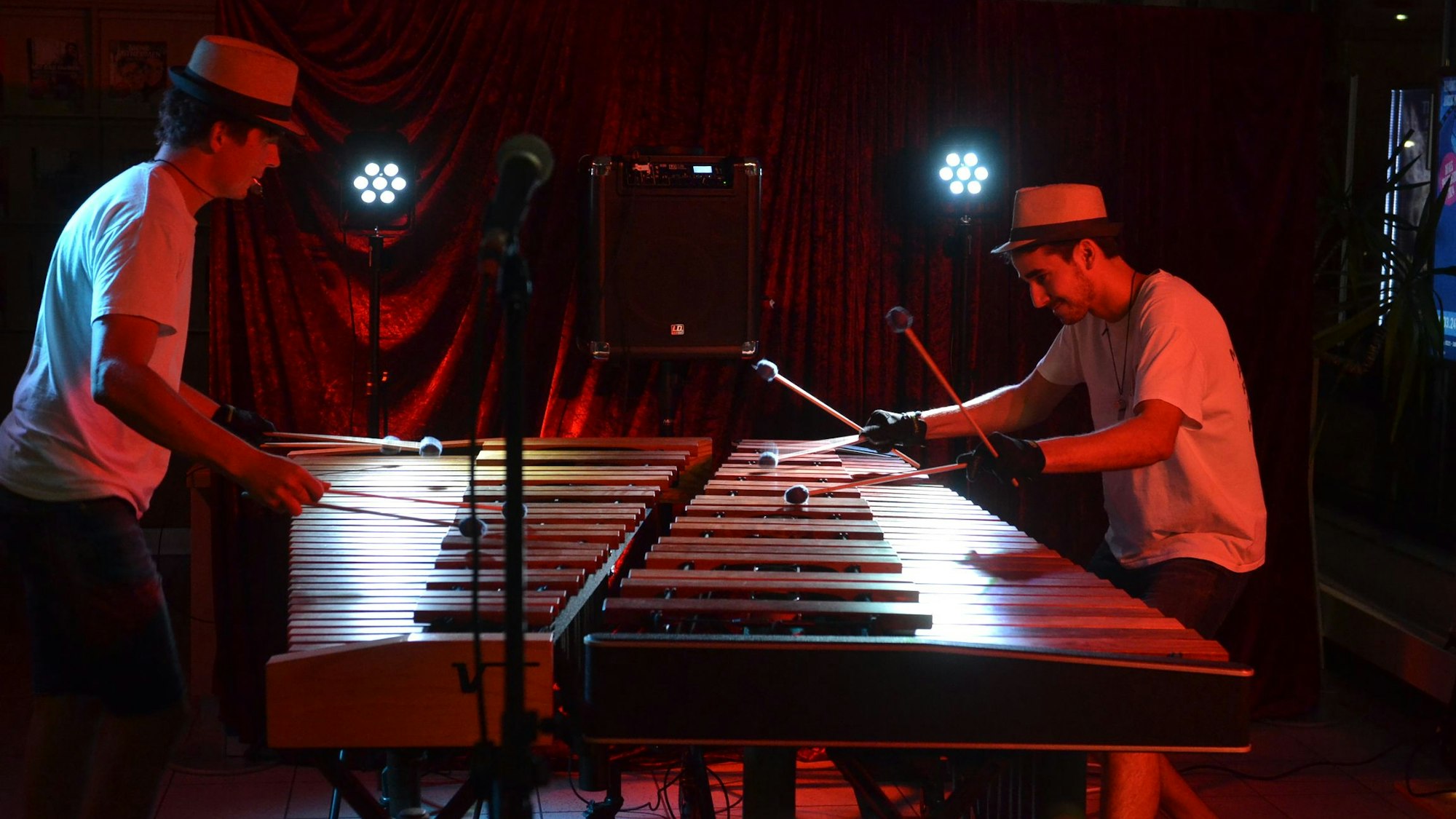 Zwei Männer mit Hüten spielen Marimba.