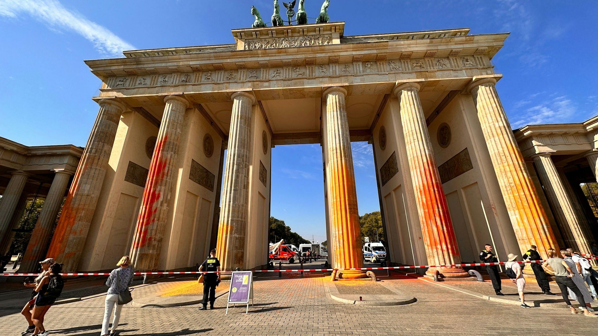 17.09.2023, Berln, Berlin: Mitglieder der Klimaschutzgruppe Letzte Generation haben das Brandenburger Tor in Berlin mit oranger Farbe angesprüht. Alle sechs Säulen seien betroffen, sagte ein Polizeisprecher am Sonntagvormittag. Einsatzkräfte seien vor Ort, es habe Festnahmen gegeben. Die Letzte Generation teilte mit, es seien präparierte Feuerlöscher für die Aktion genutzt worden. Foto: Paul Zinken/dpa +++ dpa-Bildfunk +++