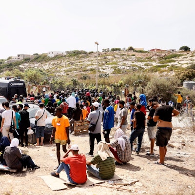 Geflüchtete vor einer Aufnahmestation auf Lampedusa, der italienischen Insel.