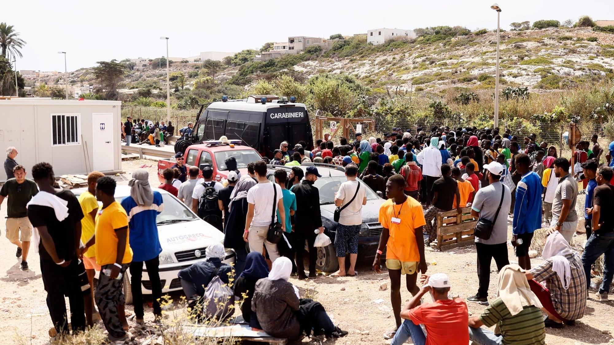 Geflüchtete vor einer Aufnahmestation auf Lampedusa, der italienischen Insel.
