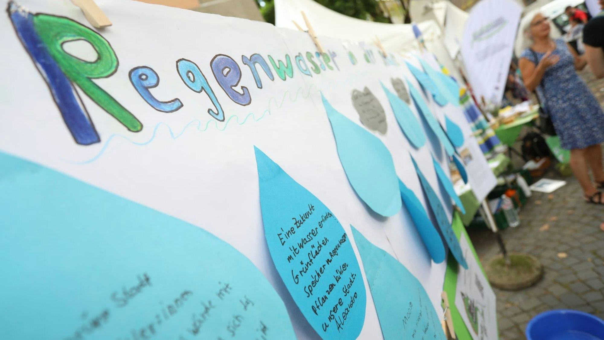 Ein großes Plakat, auf dem auf tropfenförmigen Zetteln Vorschläge stehen.