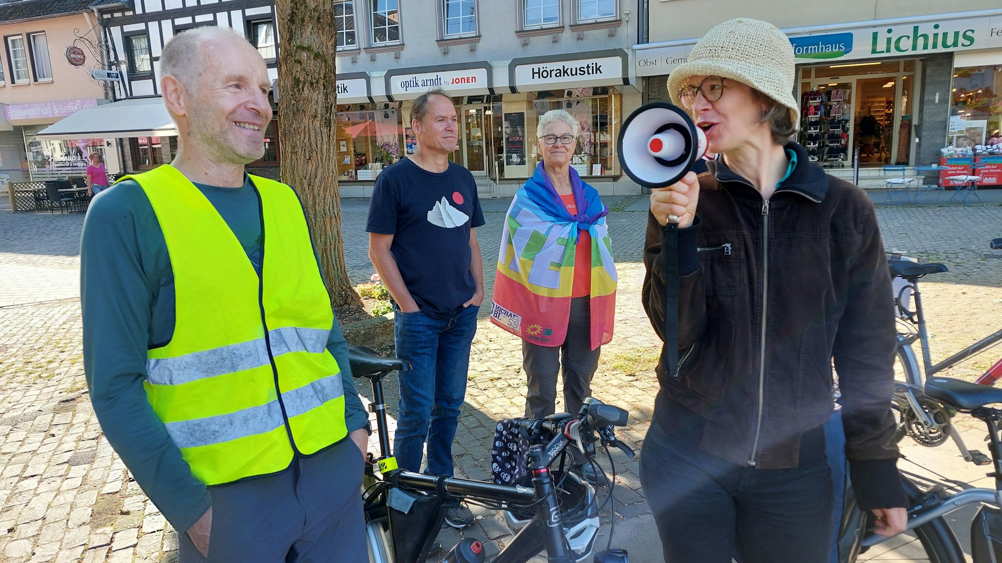 Die Organisatoren stehen mit einem Megaphon und ihren Fahrrädern auf dem Marktplatz.