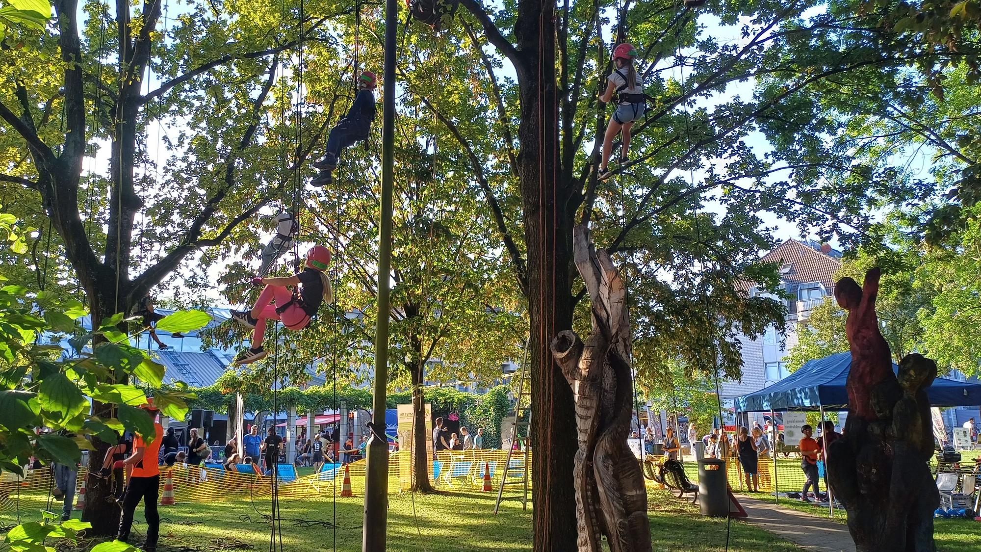 Kinder hangeln sich von Baum zu Baum am ersten Tag des Stadtfests in Leichlingen.
