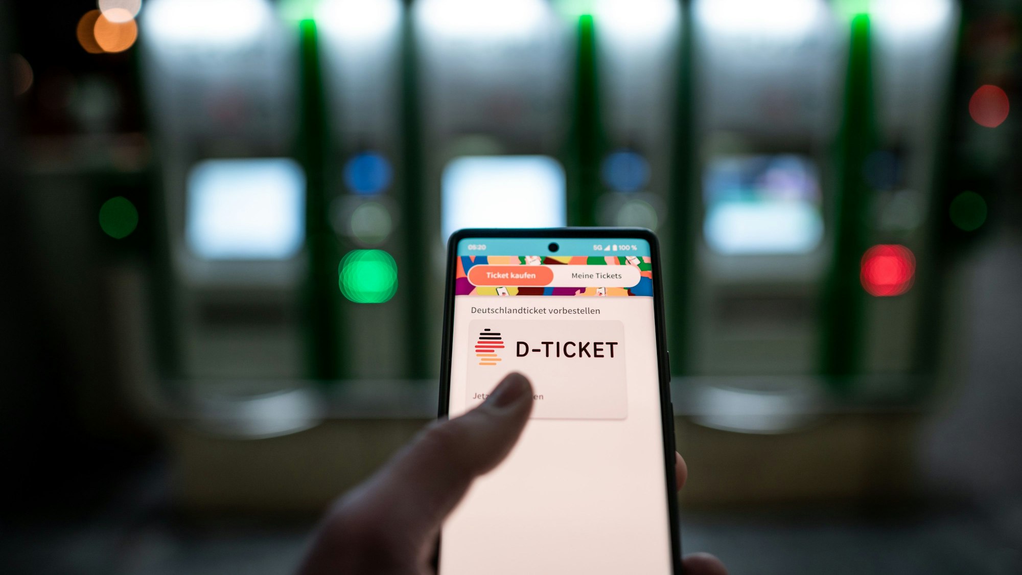 Eine Frau hält ein Smartphone in der Hand. Darauf ist das digitale Deutschlandticket zu sehen.