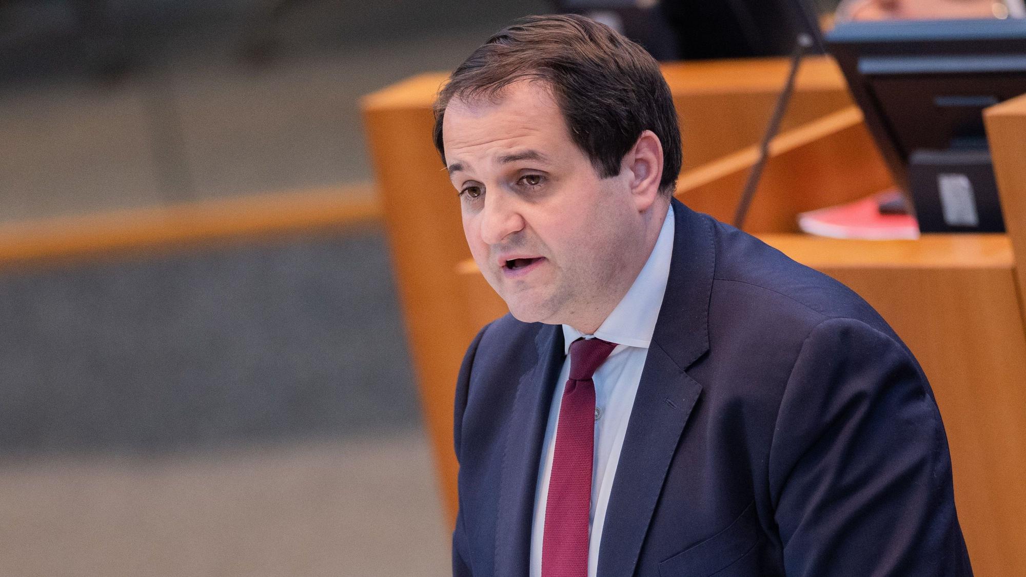 Nathanael Liminski (CDU) spricht vor einem unscharfen Pult mit Rechner im Anzug und Krawatte.
