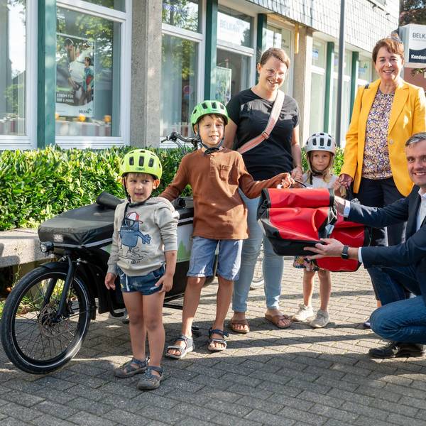 Elke Reichert und Marc Baack übergeben das Lastenrad an Familie Hutter.