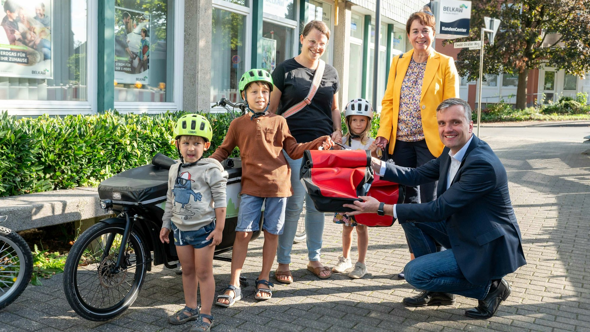 Elke Reichert und Marc Baack übergeben das Lastenrad an Familie Hutter.