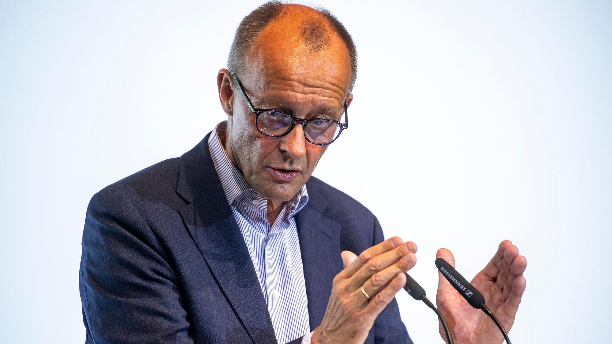 Der CDU-Bundesvorsitzende Friedrich Merz spricht und gestikuliert vor zwei Mikrofonen.