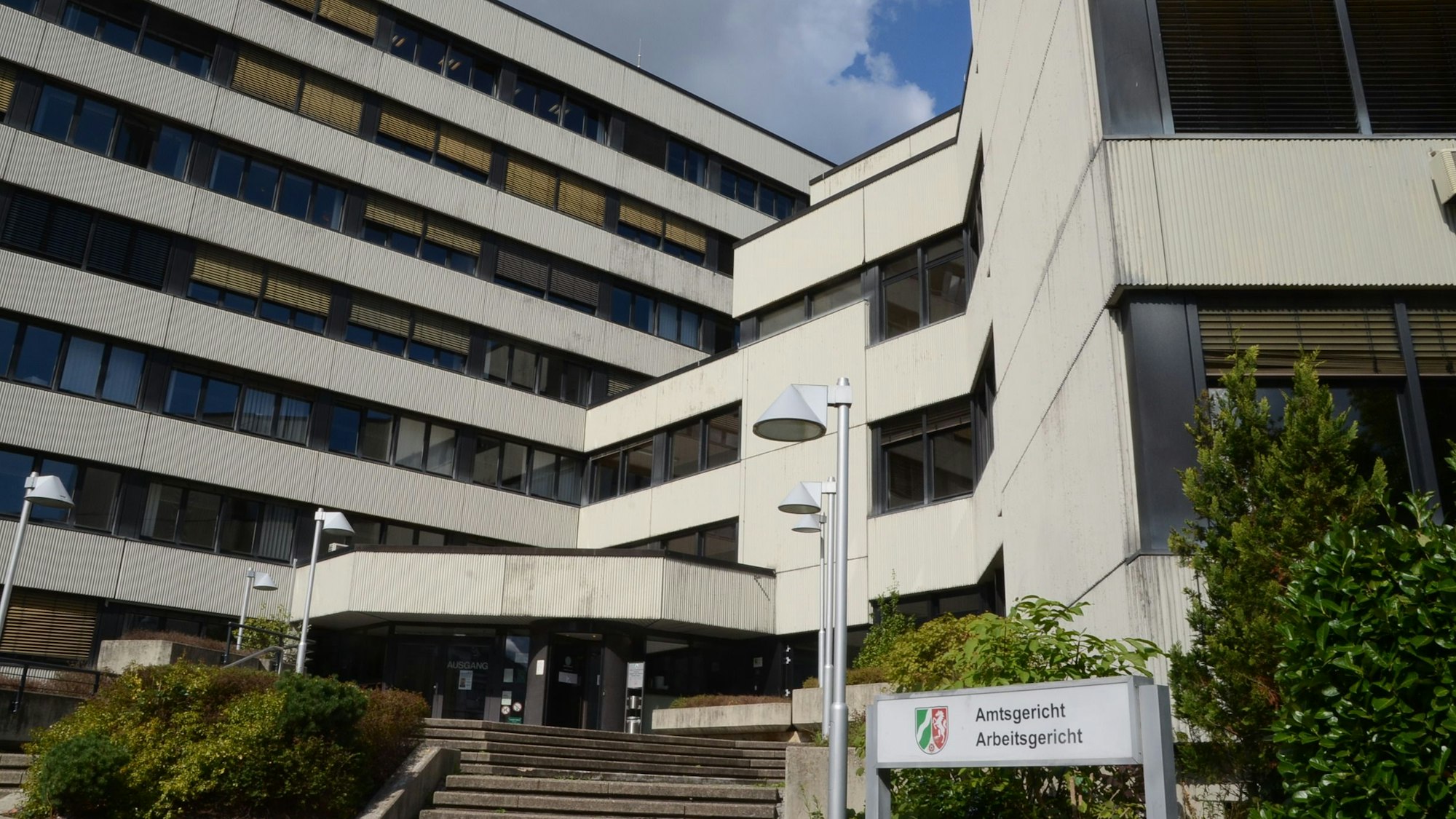 Ein Verwaltungsgebäude aus den 70er Jahren. Auf einem Schild steht Amtsgericht und Arbeitsgericht.